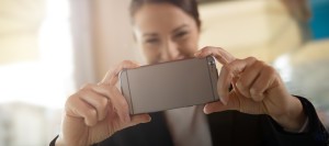 A woman taking a picture with her iPhone.