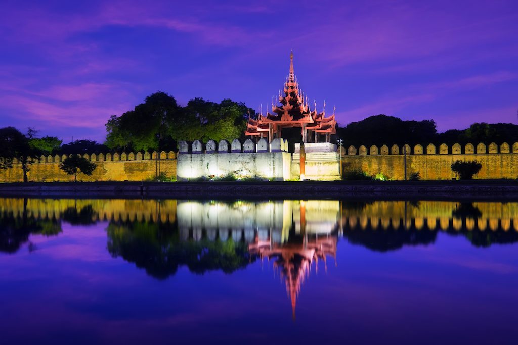 Night view of Mandalay cityscape with famous Fort or Royal Palace. Myanmar (Burma) travel landscapes and destinations