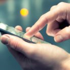 A pair of hands holding and using a smartphone
