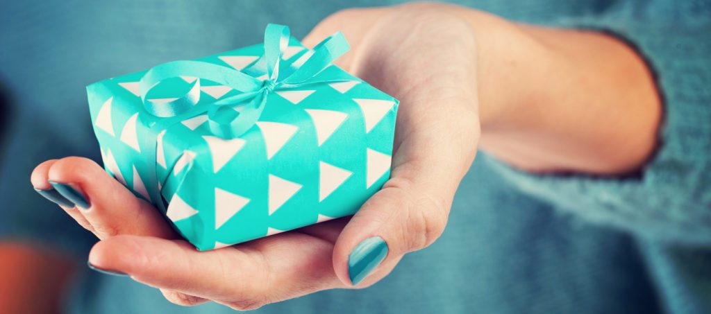 A woman's hand holding out a gift