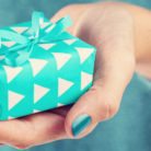 A woman's hand holding out a gift