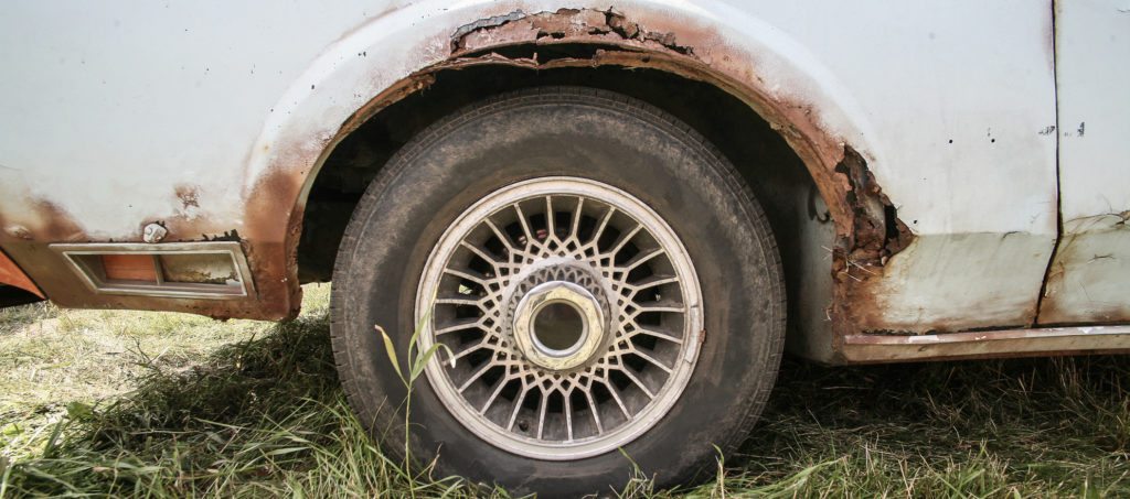 A rusted wheel well in a car