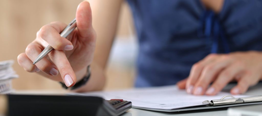 A woman accountant creating a budget using a calculator