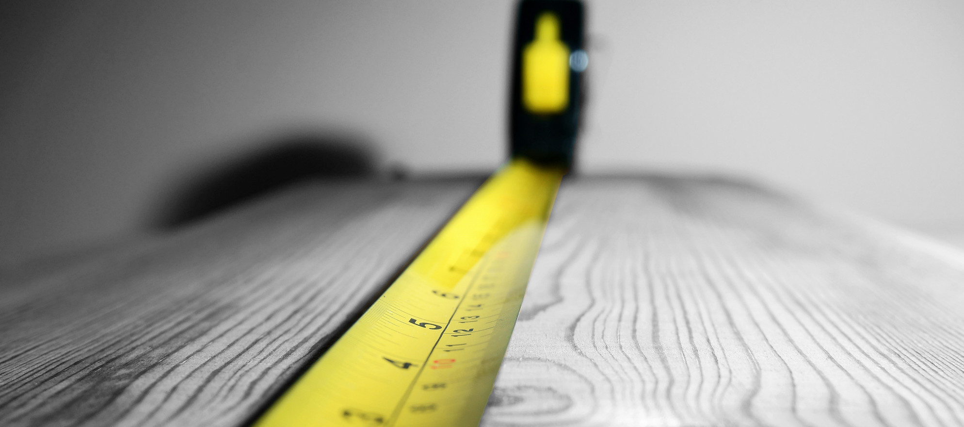 A tape measure measuring out some wood