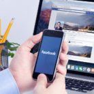A man checking Facebook on his laptop and his mobile phone