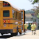 Kids getting off a school bus in blurred focus