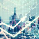 A double-exposure shot of a city and some economic graphs