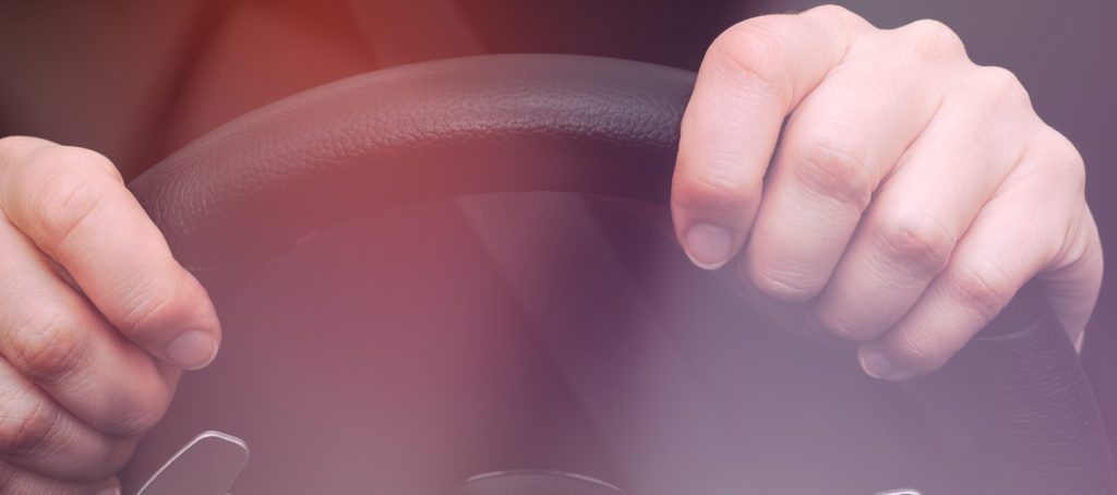 A woman's hands on a steering wheel