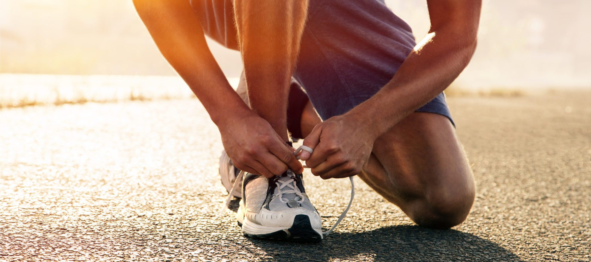 A man lacing up his shoes for a run