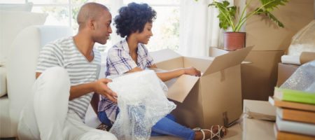 A black couple unpacking boxes in their new home