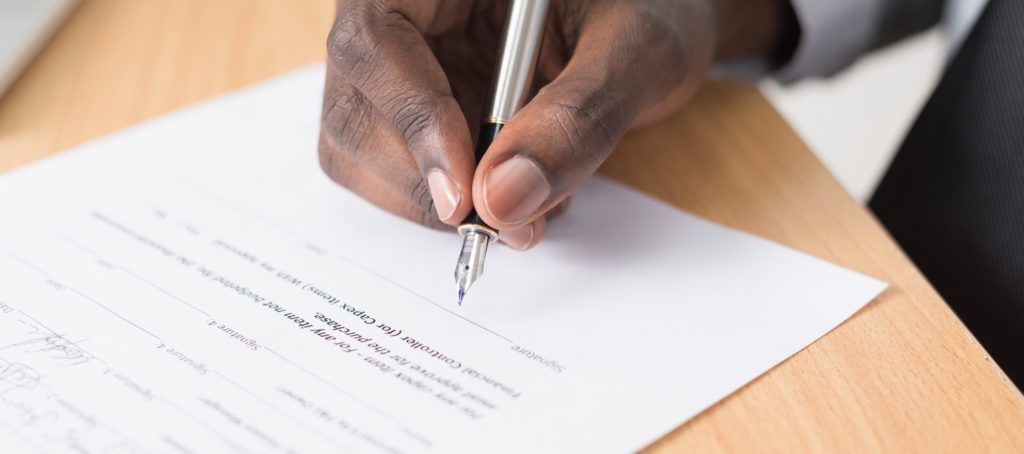 Hand signing a signature on a document