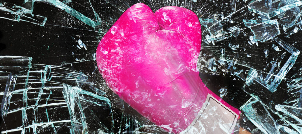 Pink boxing glove smashing glass