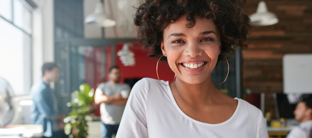 Woman smiling with man in background