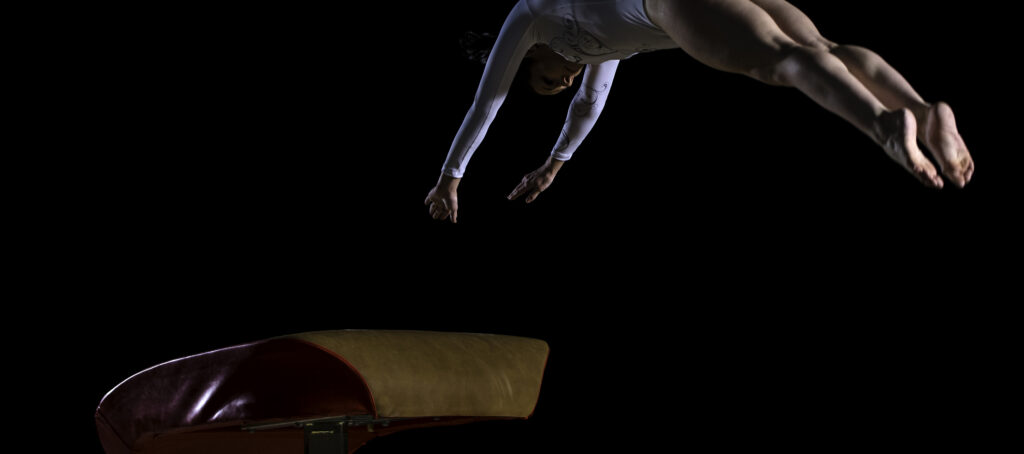 gynnast mid-flip from a vault